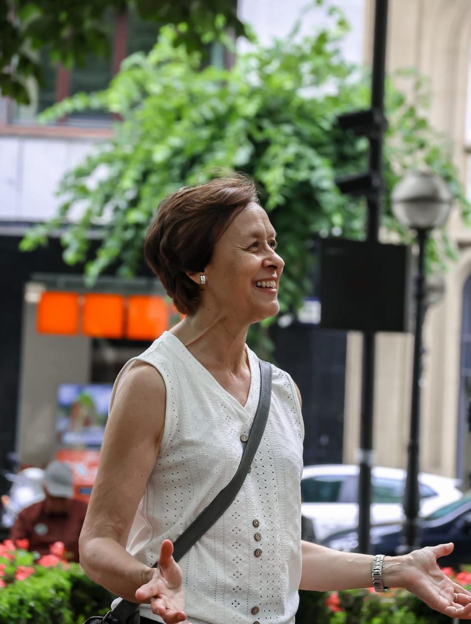 Iratxe explicando en plena calle, sonriendo con los brazos abiertos